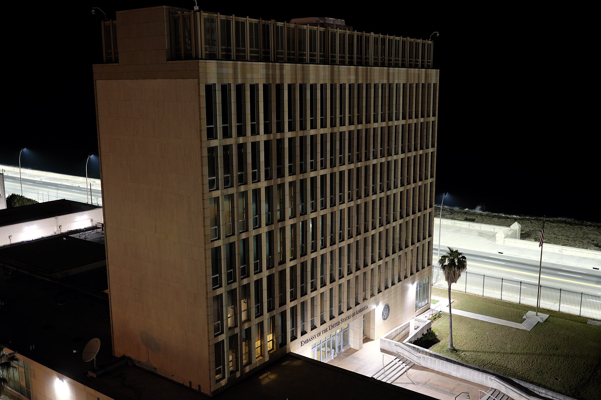 Le bâtiment de l'ambassade des États-Unis à La Havane, de nuit, à côté du Malecón